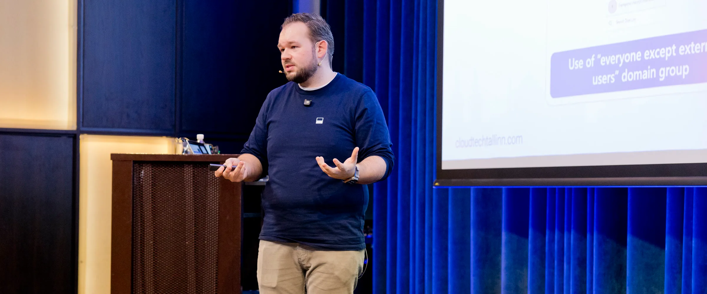 Daniel Rohregger gesturing while explaining a slide on a conference stage