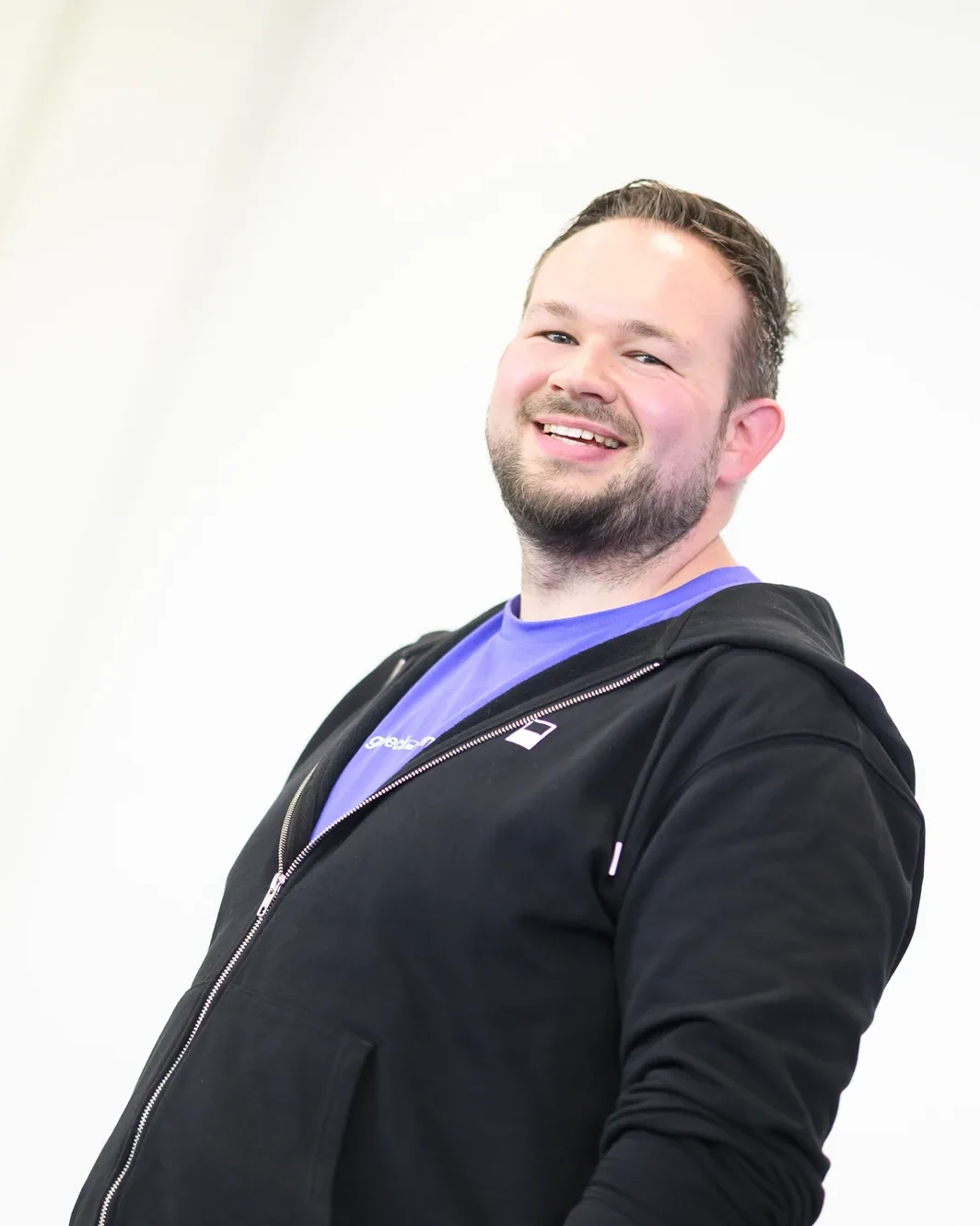 Daniel Rohregger lacht während eines Vortrags, im Hintergrund eine Softwareprojektion