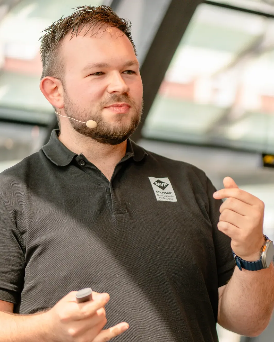 Daniel Rohregger speaking with a headset microphone, explaining with both hands during a talk